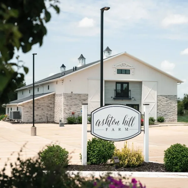 Exterior view of the Ashton Hill Farm building with a white sign in the foreground