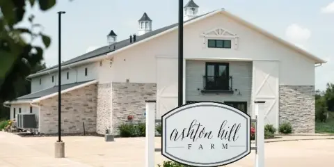 Exterior view of the Ashton Hill Farm building with a white sign in the foreground
