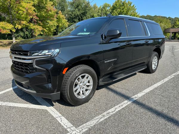 A black Chevrolet Suburban SUV parked in a parking lot.