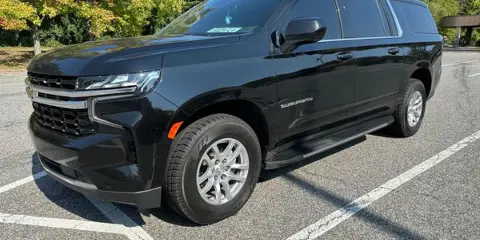 A black Chevrolet Suburban SUV parked in a parking lot.