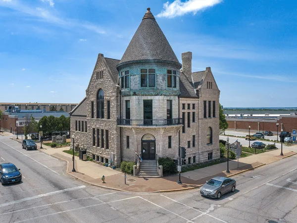 Exterior view of the John Wood Mansion, a historic stone building with a conical turret, located on a street corner.