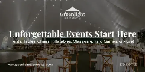 Interior of a large white event tent set up with round tables, wooden chairs, and string lights.
