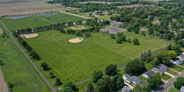 Aerial view of the Princeton Park District grounds, showing green fields, a pond, and surrounding residential areas.