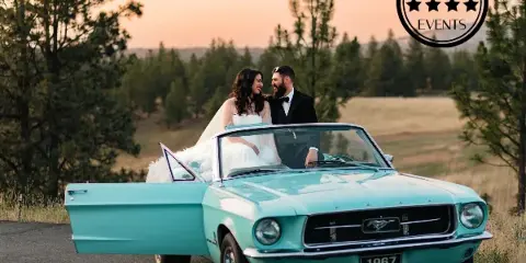 A bride and groom posing with a vintage teal 1967 Mustang convertible in a scenic outdoor setting, with the Caswell Events logo in the corner.