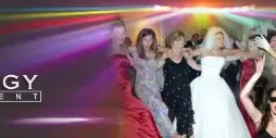 A wedding reception scene showing a bride and groom dancing with guests under colorful party lights.