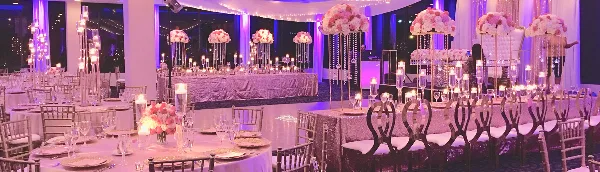 Elegant reception setup with pink floral centerpieces and string lights
