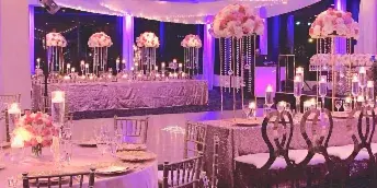 Elegant reception setup with pink floral centerpieces and string lights