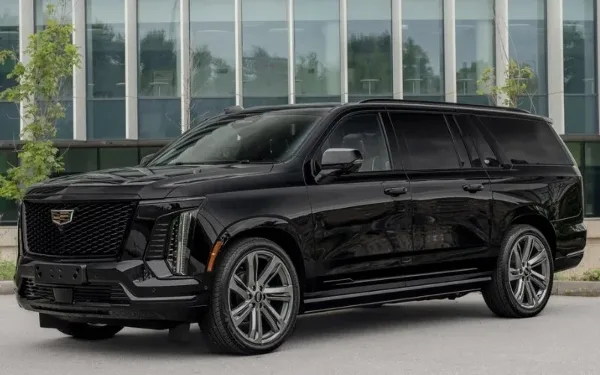 A black luxury SUV parked in front of a modern glass building.
