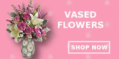 A floral arrangement featuring pink roses and white lilies in a decorative vase.