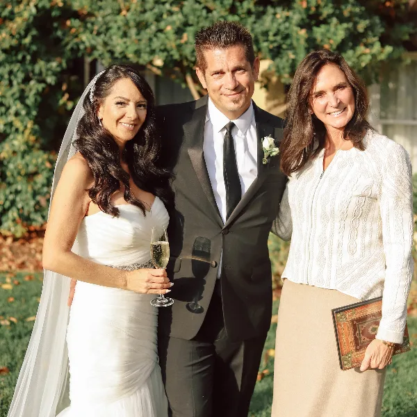 Wedding officiant Stevi Hanson posing with a bride and groom outdoors.