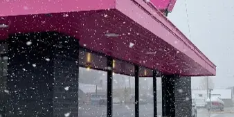 Exterior of 5B's Barbecue restaurant with pink signage in snow
