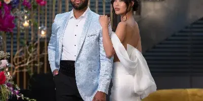 A bride and groom posing in a modern venue, showcasing the bride's styled hair and makeup.