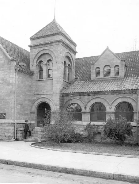 Historic stone building with a tower and arched windows, identified as the Carnegie Museum of Kings County.
