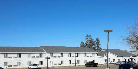 Exterior view of the Forty Club Inn motel building with a parking lot and clear blue sky.