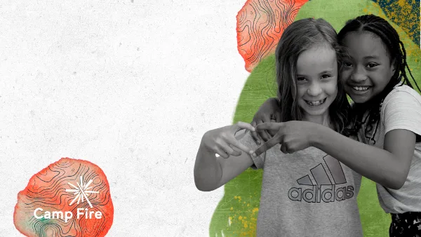 Two smiling children making a heart shape with their hands in front of a colorful background with the Camp Fire logo.