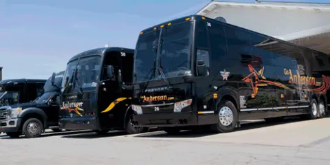 A fleet of black Anderson Coach & Travel charter buses parked in a lot.