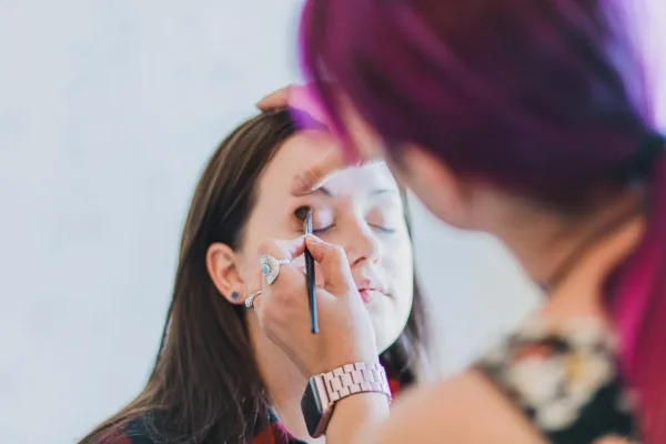 A makeup artist applying makeup to a client's face.