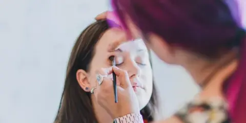 A makeup artist applying makeup to a client's face.