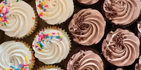 Close-up assortment of vanilla and chocolate cupcakes with sprinkles