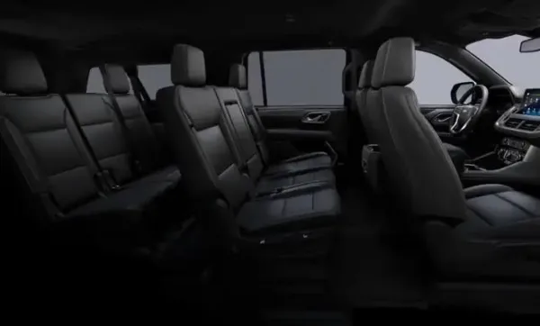 Interior view of a luxury SUV with black leather seats and multiple passenger rows.