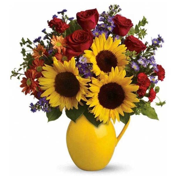 A floral arrangement featuring sunflowers, red roses, and purple flowers in a yellow pitcher vase.