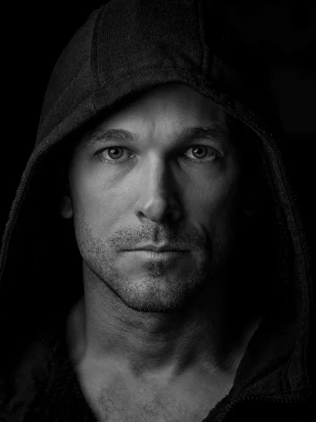 Black-and-white portrait of a man wearing a hood, shown as a sample of Steele House Photography’s work.