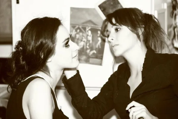 A makeup artist applying makeup to a client in a studio setting.
