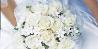 White rose and star jasmine bridal bouquet held by a bride in a white gown