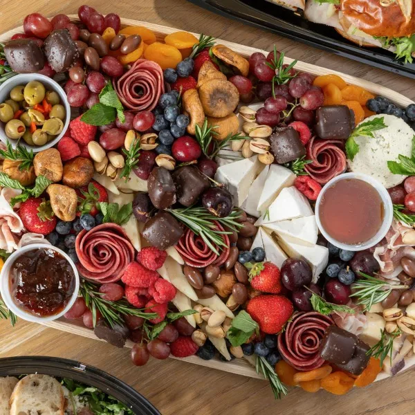 A large charcuterie board with assorted cheeses, meats, and fruits.
