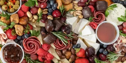 A large charcuterie board with assorted cheeses, meats, and fruits.