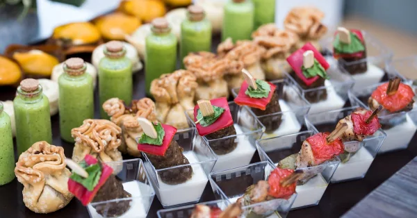 Assorted wedding hors doeuvres including savory bites, vegetables, and sauces arranged in serving dishes.