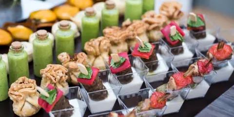 Assorted wedding hors doeuvres including savory bites, vegetables, and sauces arranged in serving dishes.