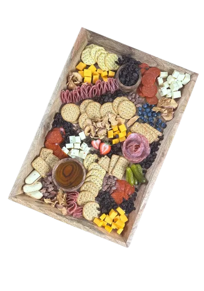 A wooden tray filled with an assortment of charcuterie meats, cheeses, crackers, dried fruit, and fresh berries.