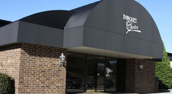 Exterior view of the AVS Catering & Banquet Centre building entrance with brick facade and 'Banquet Centre' signage on the awning
