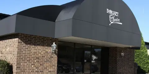 Exterior view of the AVS Catering & Banquet Centre building entrance with brick facade and 'Banquet Centre' signage on the awning