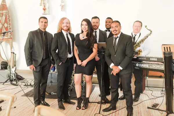 A professional live band performing at an event with various instruments and a singer.