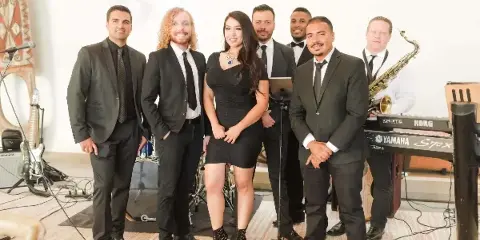 A professional live band performing at an event with various instruments and a singer.