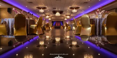 Interior of an elegant banquet hall with a dance floor, chandeliers, and decorated tables.