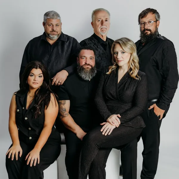 A professional group portrait of the Crossroads Entertainment team, consisting of six individuals in black formal wear.