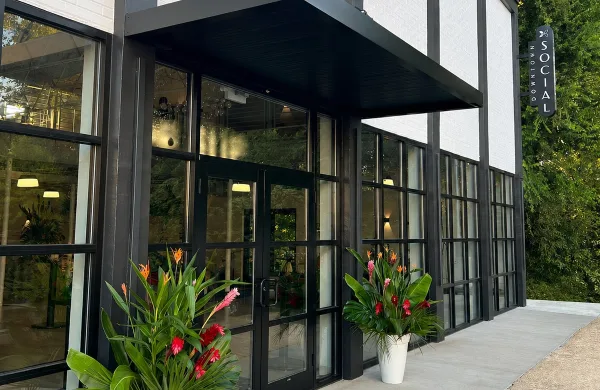 Exterior view of the Downtown Social event venue entrance featuring black-framed glass doors and a vertical sign.