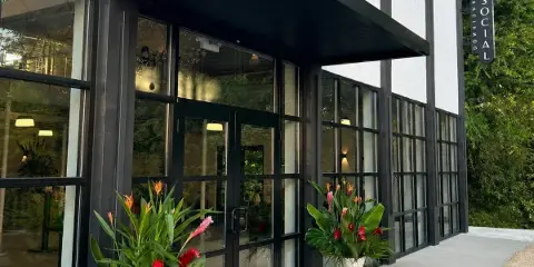 Exterior view of the Downtown Social event venue entrance featuring black-framed glass doors and a vertical sign.