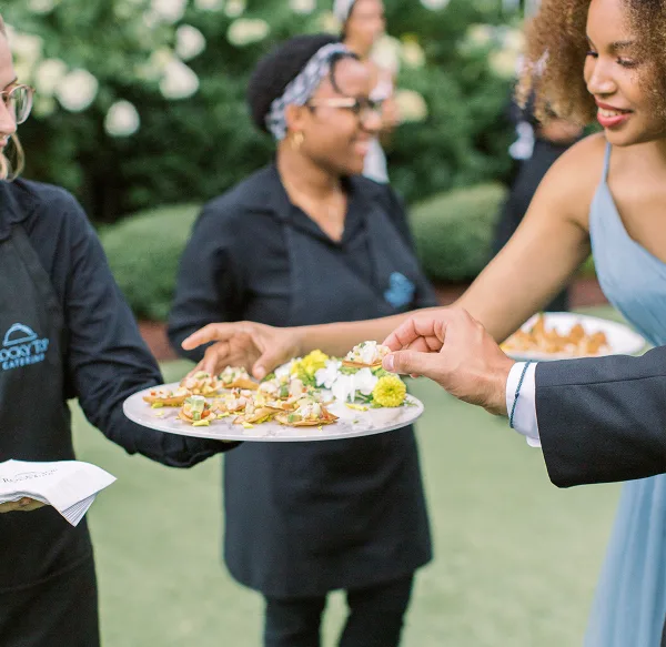 Rocky Top Catering staff serving appetizers to guests at an outdoor event
