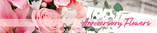 A close-up photograph of a floral arrangement featuring pink roses, lilies, and eucalyptus leaves.