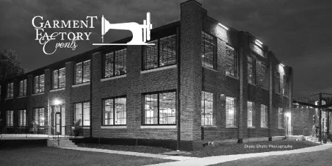 Exterior view of a large, historic brick building with multiple windows, illuminated at night, identified as the Garment Factory Events venue.
