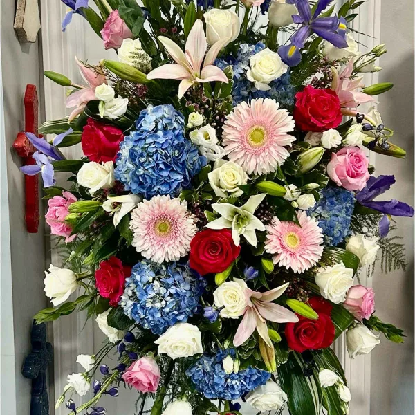 Tall standing floral spray with roses, lilies, hydrangeas, and gerbera daisies