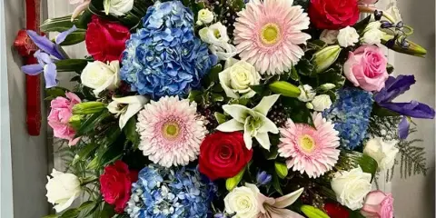 Tall standing floral spray with roses, lilies, hydrangeas, and gerbera daisies