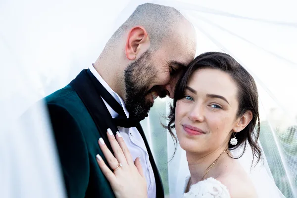 A bride and groom sharing an intimate moment, with the groom kissing the bride's forehead.
