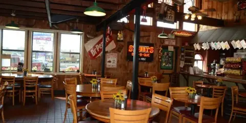 Interior view of the Stubby's BBQ restaurant dining room with wooden tables and chairs.
