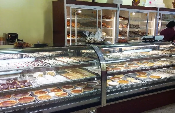 Bakery display case filled with pies, pastries, and cakes in a neighborhood bakery