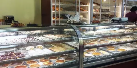 Bakery display case filled with pies, pastries, and cakes in a neighborhood bakery